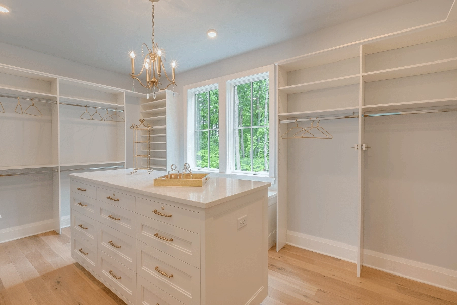 empty luxury closet in large home with chandelier and extra storage